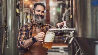 Master brewer tasting beer in the production facility.