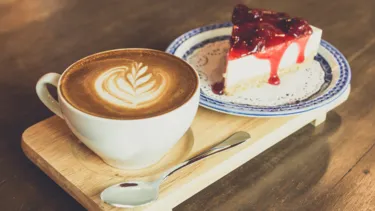 Strawberry cheese cake and latte coffee on wood table