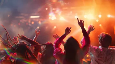 Group of people dancing at a concert.