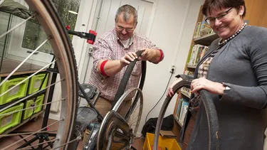 Mann und Frau reparieren gemeinsam ein Fahrrad