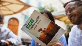 Young Couple is reading in a travel guide "Eco Travel Guide"