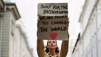 Woman holding a sign and protests for more equality.