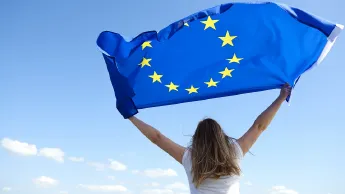 Frau hält Europa-Flagge in die Luft