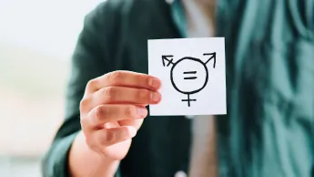 Ausgeschnittenes Bild einer Person, die ein Blatt Papier hält, das die Gender Symbole abbildet