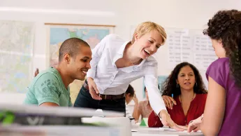 Kursteilnehmende mit Lehrerin im Klassenraum