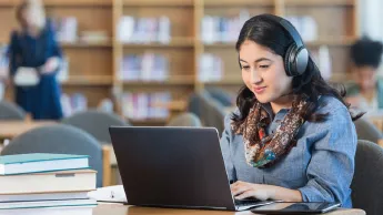 Young Woman with headphones working on her laptop