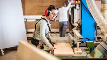 Junge Schreinerin bei der Arbeit in der Werkstatt