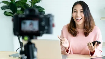 Junge Frau vor der Kamera dreht ein Video