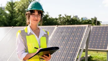 Junge Frau, die im Solarkraftwerk arbeitet