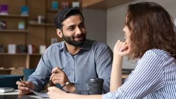 Latin American man and woman exchange ideas during mentoring on career topics