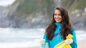 Young woman cleaning up beach