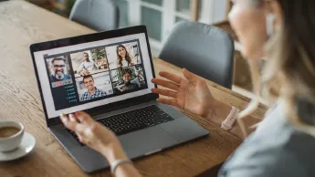 Eine Frau sitzt vor dem Laptop und nimmt an einem Online-Seminar teil