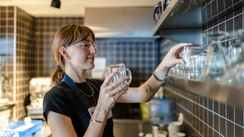 Young female student works in a coffee shop