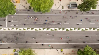 Three-lane road that is used as a cycle lane in both directions. The road is lined with trees.