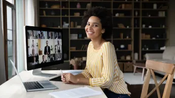 Portrait of a smiling African-American young woman hosting an online event.