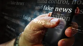 hand with mobile phone and text disinformation fake news