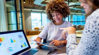 Two women working together on a presentation