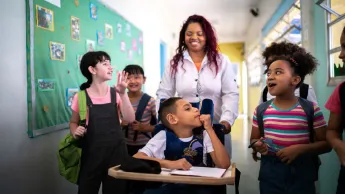 Teacher with pupils in the school corridor, including a child with a disability