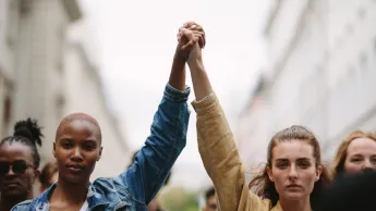 Gruppe von Frauen, die sich an den Händen halten und gemeinsam protestieren