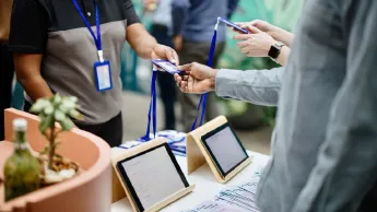 People check in at a conference and receive their name badges