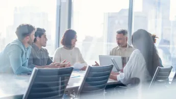 Diverse group of Business people during a meeting with copy space. They are sitting in a board room, All are casually dressed.