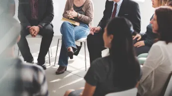 Eine Gruppe von Menschen sitzt im Kreis und tauscht sich zu Wissenschaft aus