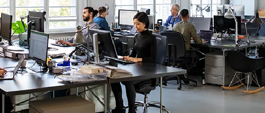 Young people work on their computers in a modern open-plan office