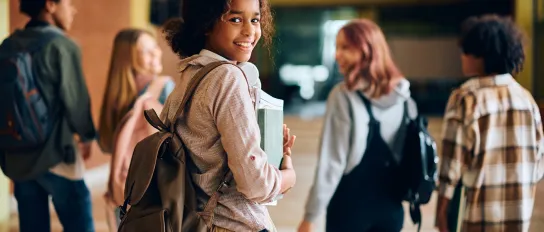 High school student walking through hallway with her friends