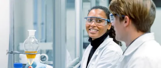 A young chemist talks to her colleague in the laboratory